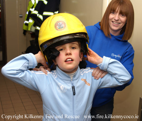 A Saplings student tries on a Firemans Helmet