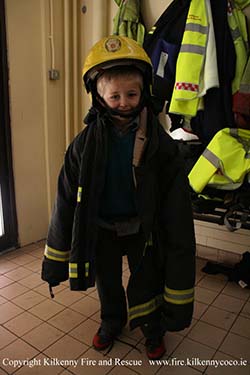 Child trying on a Firemans Uniform